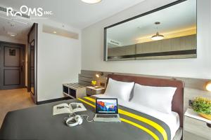 1 dormitorio con 1 cama y escritorio con ordenador portátil en Rooms Inc Semarang, en Semarang