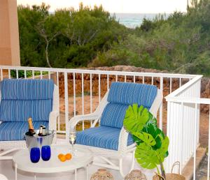 two chairs and a table on a porch at Apartments Es Trenc in Ses Covetes