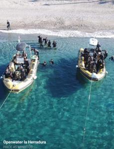 two boats in the water with people on them at Pension los Verdiales in La Herradura