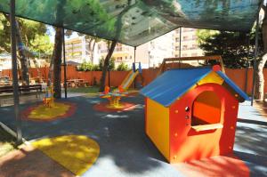 un parque infantil con una casa de juegos y un tobogán en HomeHolidaysRentals Solmar, en Santa Susanna