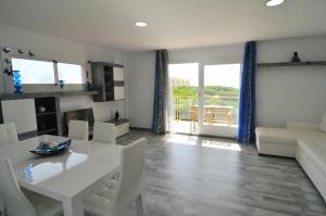 sala de estar con mesa blanca y sillas en HomeHolidaysRentals Solmar, en Santa Susanna