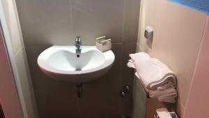 bagno con lavandino bianco e asciugamano di San Giorgio Rooms a Caltagirone Altre 16 foto