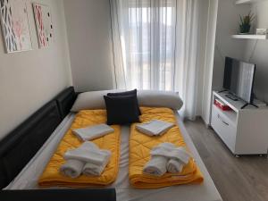 a bedroom with a bed with towels and a tv at Rovena's Apartment - free parking in Tirana