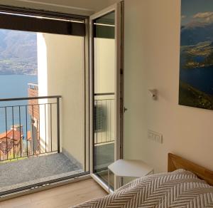 a bedroom with a bed and a large window at Casa MICHI in Dervio