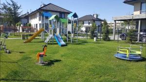 un parque con parque infantil con toboganes y equipo de juegos en Apartament 13 Ustronie Morskie en Ustronie Morskie