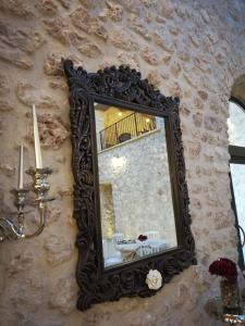 a mirror hanging on a stone wall with a table at Tenuta Terra e Sole in Castrocielo