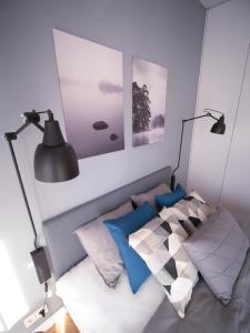 1 dormitorio con 2 lámparas y 1 cama con almohadas en VipWarsawApartments Onyx Mennica Residence en Varsovia