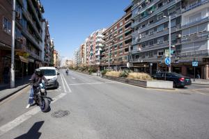 una persona que conduce una motocicleta por una calle de la ciudad en Arabial Deluxe, en Granada