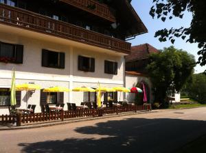 un edificio con mesas, sillas y sombrillas en Gasthof Pension Steinberger en Sankt Georgen im Attergau