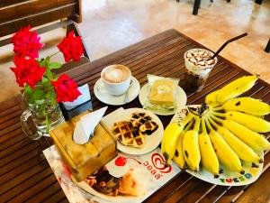 einen Tisch mit Teller mit Lebensmitteln und Bananen drauf in der Unterkunft Bannsuan Amaleena in Ko Yao Noi