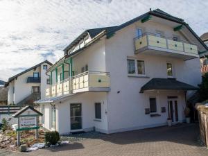 ein großes weißes Gebäude mit Balkonen darauf in der Unterkunft Modern Apartment in Schwalefeld Germany near Ski Area in Willingen