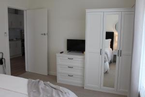 a bedroom with a bed and a dresser with a mirror at Annie's Apartment in Mount Gambier +21 photos