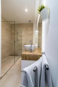 a bathroom with a shower, sink, and tub at Hotel Cool Zagreb Airport in Velika Gorica