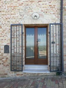 a wooden door on a brick building with metal gates at Il nido della rondine, appartamento nel borgo medievale in Cartoceto