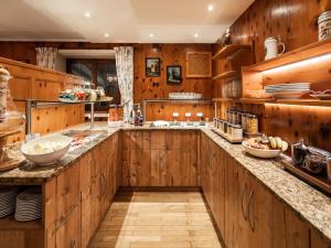 a kitchen with wooden cabinets and a large island at Haus Daheim in Oberstaufen