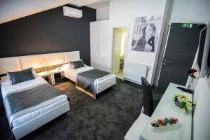 um quarto de hotel com duas camas e uma mesa em Hotel Cool Zagreb Airport em Velika Gorica