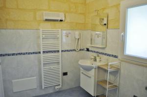 baño con lavabo y teléfono en B&B Lecce Holidays, en Lecce