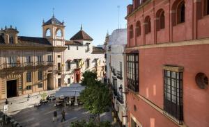 una vista aérea de una calle de la ciudad con una torre del reloj en Apartamentos Altamira, en Sevilla