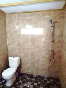 a bathroom with a toilet and a shower at Villa Rikna in Watukarung +10 photos