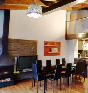une salle à manger avec une table, des chaises et une cheminée dans l'établissement Fantástica casa adosada en Prullans, à Prullans