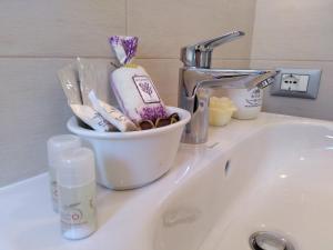 a bathroom sink with a basket of toothbrushes at Stella di Mare in La Spezia