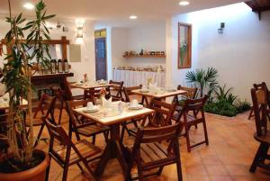 a dining room with wooden tables and chairs in a restaurant at Pousada Vila do Imperador in Diamantina