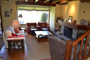 sala de estar con sofá y chimenea en Casa adosada con gran jardín en Fontanals, en Soriguerola