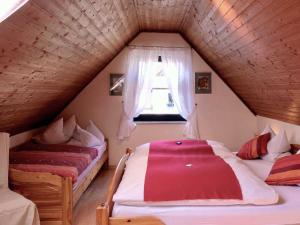 - une chambre mansardée avec 2 lits et une fenêtre dans l'établissement Ferienhaus Trautner, à Muggendorf
