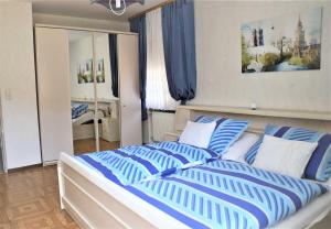um quarto com uma cama grande e almofadas azuis e brancas em Ferienwohnung Röhrer em Obertrubach