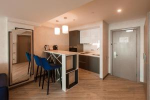 een keuken met een aanrecht en enkele blauwe krukken bij Radisson Hotel Baku in Baku +130 foto's