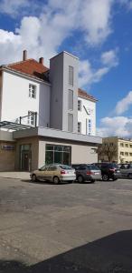 a building with cars parked in a parking lot at Hotel Azyl in Gorzów Wielkopolski