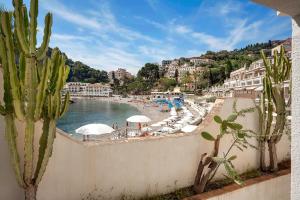 - Vistas a una playa con sombrillas y agua en Residence Degli Agrumi Mare, en Taormina
