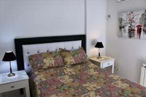 1 dormitorio con 1 cama y 2 mesitas de noche con lámparas en Departamentos Córdoba Holder II en Córdoba