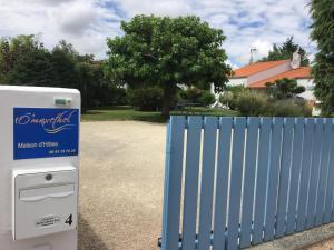 una cerca azul junto a una caja de correo junto a una puerta en Ô'Maxethel, en Soullans