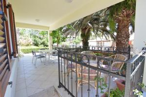 a balcony with a table and chairs and a tree at House Oskar in Mali Lošinj