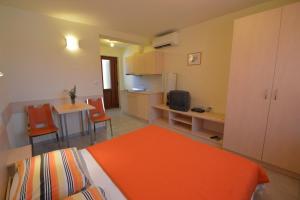 a room with a bed and a table and a kitchen at House Oskar in Mali Lošinj