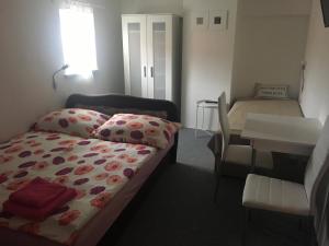 ein kleines Zimmer mit einem Bett, einem Tisch und einem Stuhl in der Unterkunft Rodinný penzion in Mikulov