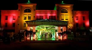 un edificio iluminado con luces rojas y verdes en Midtown Grand en Hisār