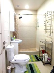 La salle de bains est pourvue d'une douche et de toilettes blanches. dans l'établissement Apartment on Ostrovskogo 59a, à Sotchi