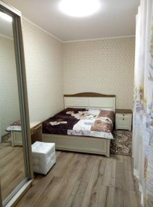 - une chambre avec un lit et un miroir dans l'établissement Apartment on Ostrovskogo 59a, à Sotchi