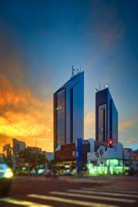 two tall buildings in a city at sunset at Central Park Hotel by Bourbon Cascavel in Cascavel