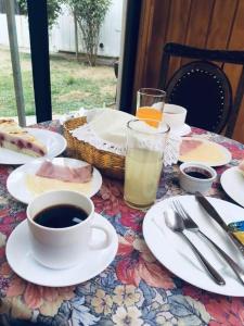 una mesa con platos de comida y una taza de café en Hostal Buenaventura, en Valdivia
