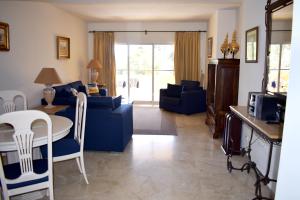 - un salon avec un canapé bleu et une table dans l'établissement Greenlife Village Apartment, à Marbella