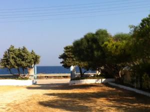a beach with trees and the ocean in the background at Porto Milos in Adamantas