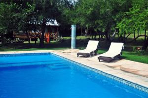 2 sillas sentadas junto a una piscina en Enkel Cabañas en José de la Quintana