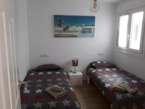 een slaapkamer met 2 bedden en een foto aan de muur bij Appartement Laduna , Résidence Ventura in Tarifa