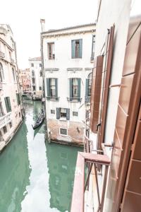 a view from a window of a canal with a boat at Rialto Canal View Deluxe R&R in Venice