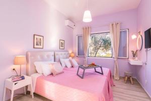 1 dormitorio con cama rosa y ventana en Lamda Apartments by Estia en Roda