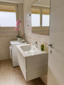 a bathroom with a sink and a mirror at Cabà Holiday Bardolino Santa Cristina in Bardolino +32 photos