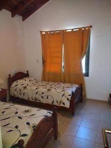 1 dormitorio con 2 camas y ventana en Cabañas Quinco en Merlo